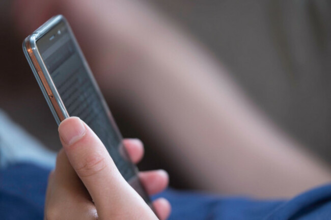 man-lying-on-the-couch-and-scrolling-and-reading-messages-on-his-smartphone-narrow-depth-of-field